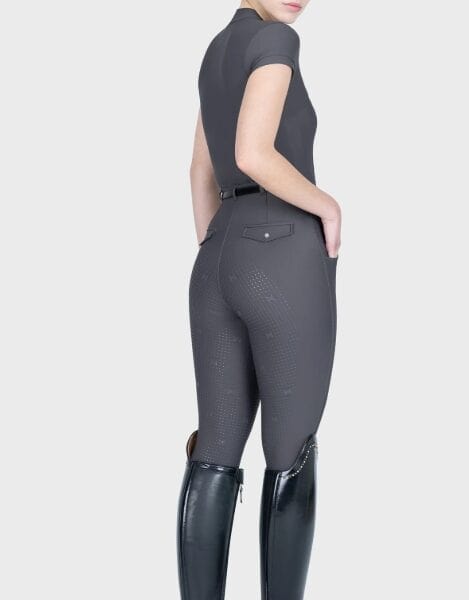 A woman in sportswear, wearing a black T-shirt and grey leggings; a sportswear outfit; sportswear.